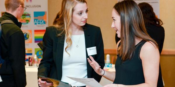 a business school student engaged with a corporate partner at a recruitment event