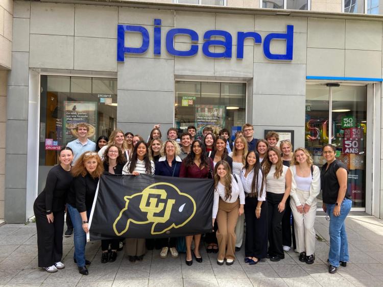 Estudiantes de pie con la bandera de CU