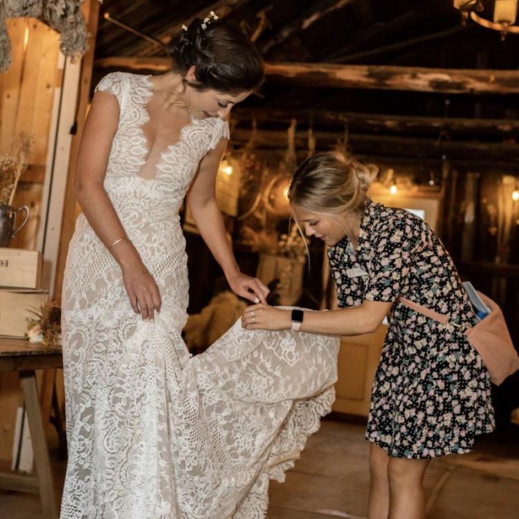 Sarah Lurie fixing a dress for one of her brides
