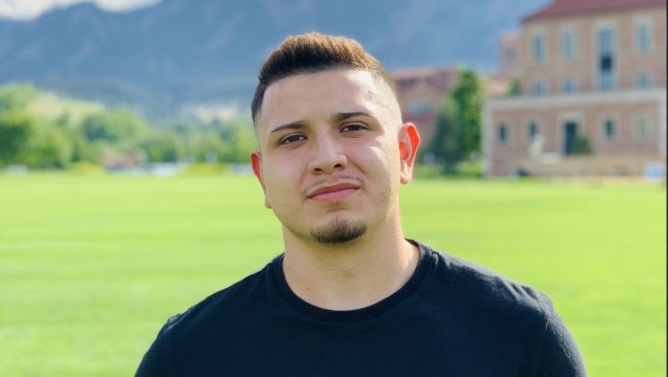 Headshot of David Lopez outside on the lawn by Koelbel, Flatirons in the background