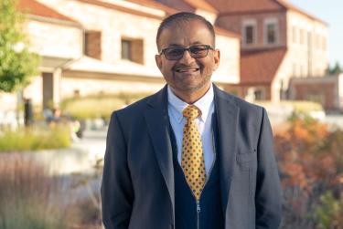 Dean Khatri poses in front of the Koelbel Building