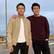 Two students pose on a basketball court.