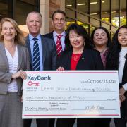 A group of professionals and students poses with a check from KeyBank to support diversity initiatives at Leeds.