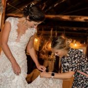 Sarah Lurie fixing a dress for a bride