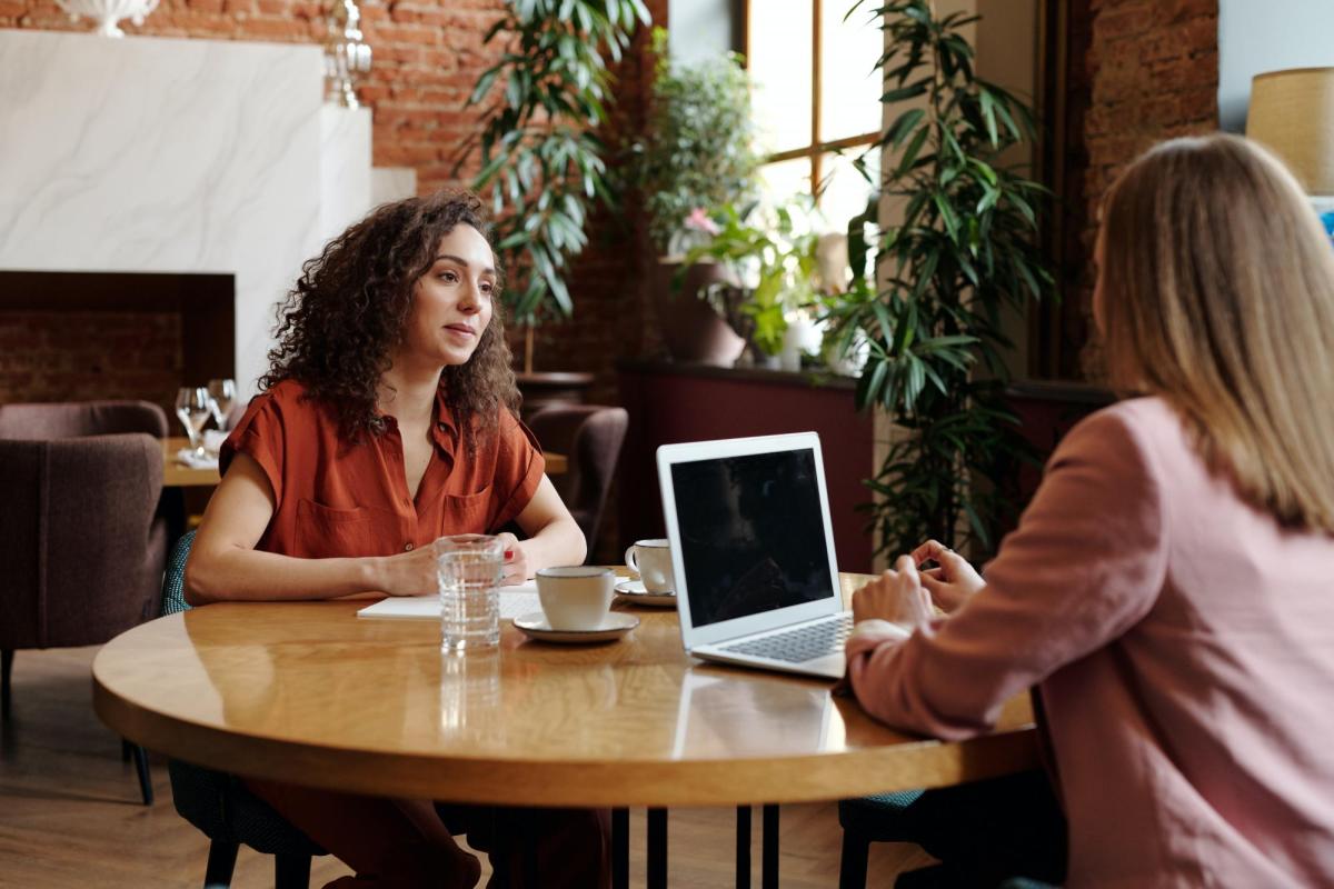 two women talking at a table