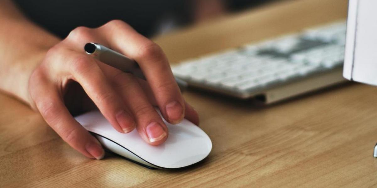 person clicking on a laptop with a mouse