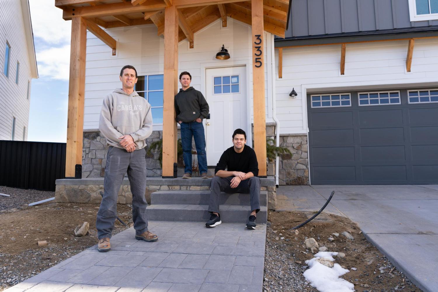 Matt Morris and the two students who helped build his home in front of his newly-built home