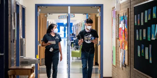 CU Boulder alumna Halle Sago, left, and undergraduate student Ricardo Reyes, right, visit High Peaks Elementary School in Boulder, Colorado, to monitor air quality. 