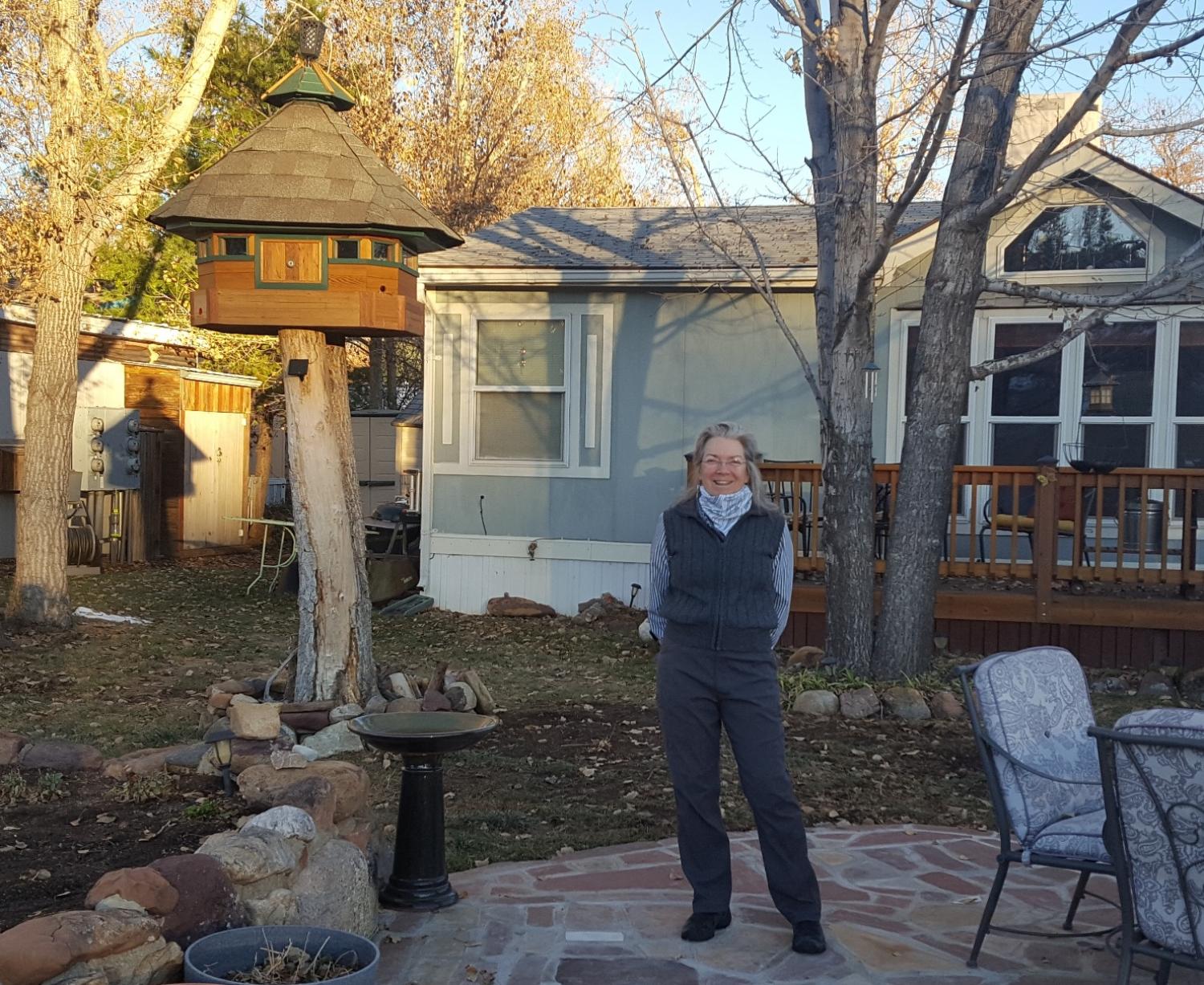 Peggy Kuhn stands in her back yard with her manufactured home behind her.