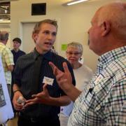 Carson Byerhof explains his poster to an attendee