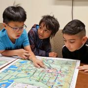 Whittier Elementary first-graders Sean Lee, from left; Tevin Loku Umagiliyage and Eber Garcia-Gonzalez get their first look at a kid-friendly map of Boulder they helped create through Growing Up Boulder. Growing Up Boulder, a collaboration among Boulder, the Boulder Valley School District and the University of Colorado Boulder, worked with about 700 elementary students for the project.