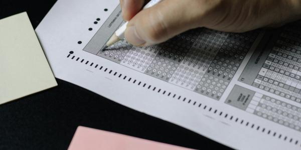 hand filling out a scantron exam