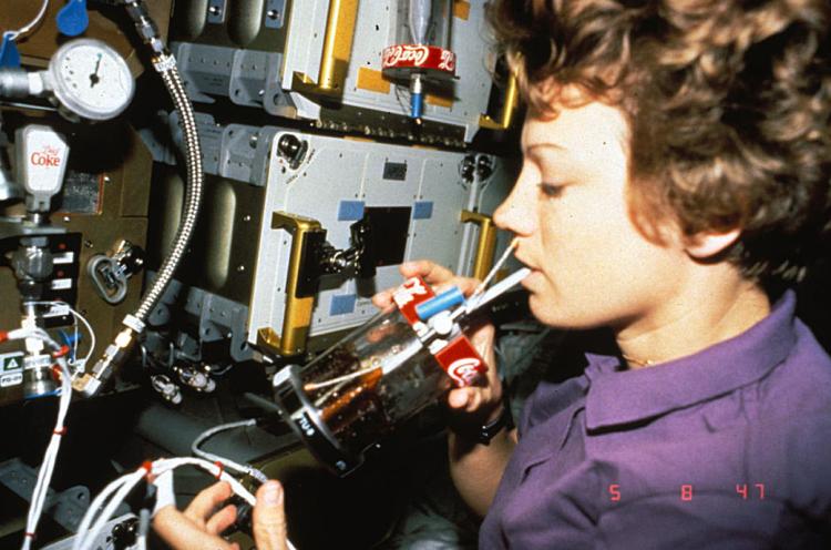NASA astronaut Eileen Collins drinking Coke out of an FTU on STS-67