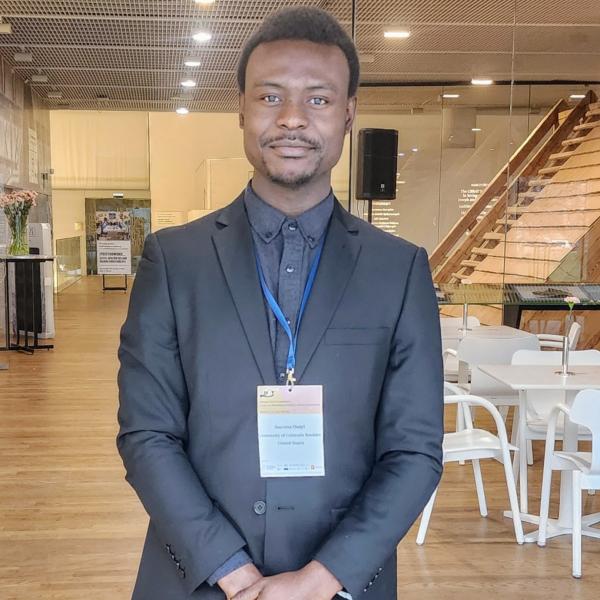 Osayi photographed standing in front of a staircase