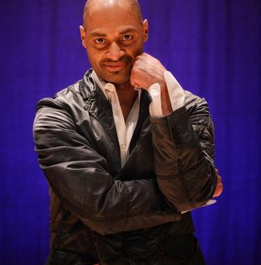 Helanius Wilkins photographed standing in front of a blue background.