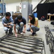 A group of students discuss the design of their steel bridge