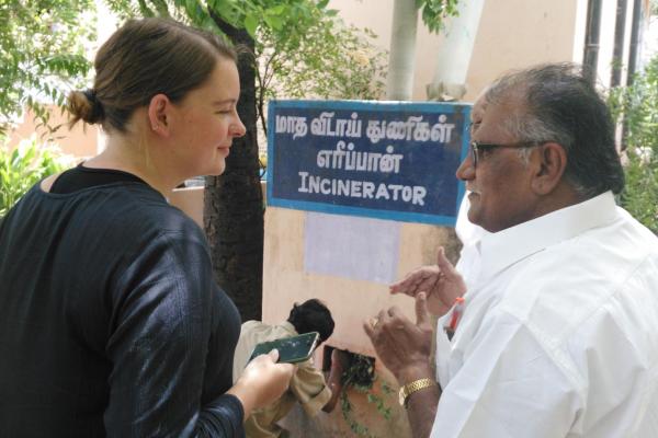 Student Allie Davis speaks to a man, next to a bilingual sign