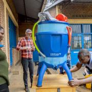 3 people gathered around a water filter