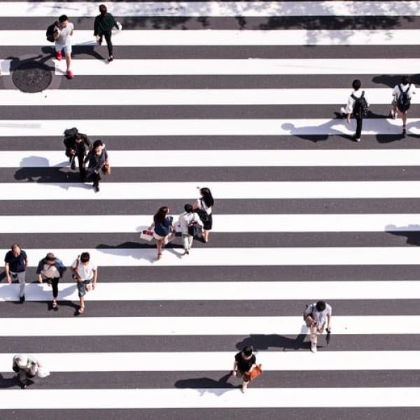 crowds of people walking on a striped surface