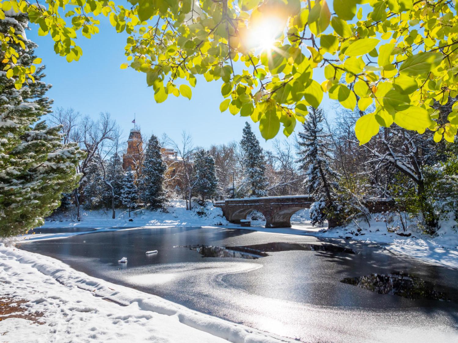 CU Boulder campus during winter with snow on top of a pond