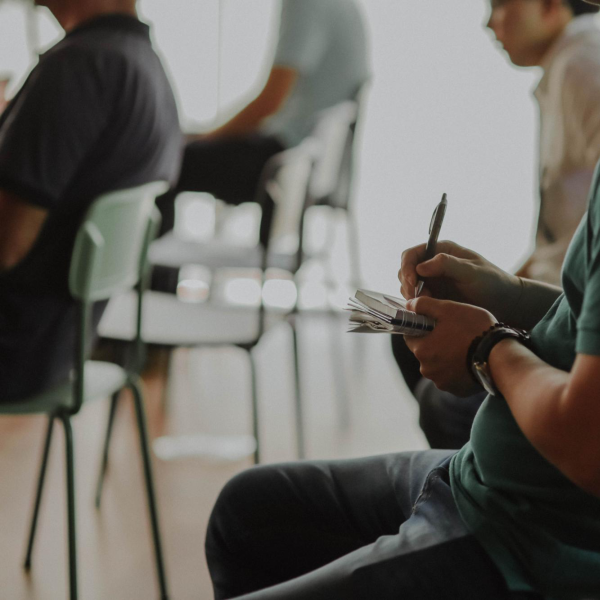 a person observing a lecture and taking notes