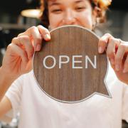 person holds a sign that says open