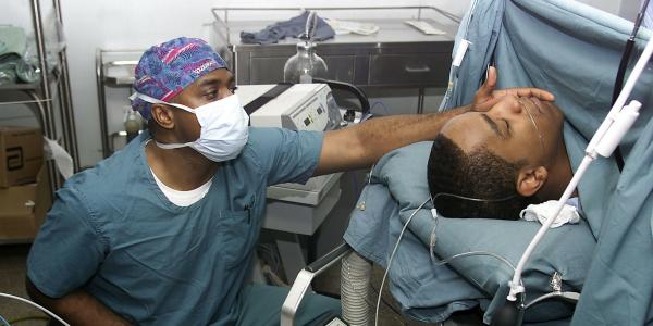 Anesthesiologist monitors patient.