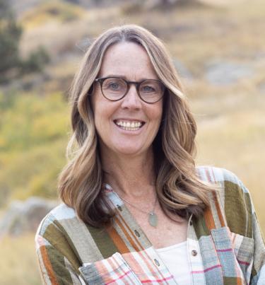 Woman with glasses smiling at camera