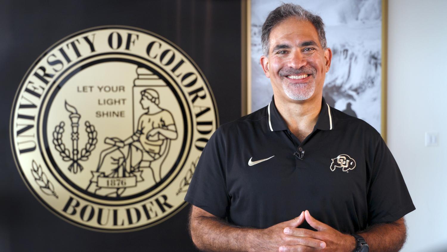 Justin Schwartz in front of the university seal