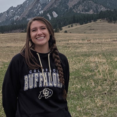 Jenna Trost in Buffs sweater in front of the mountains