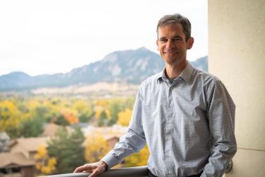 Will Medlin on balcony  overlooking Boulder foilage and mountains