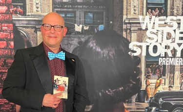 Professor Ernesto Acevedo-Muñoz in front of "West Side Story" poster