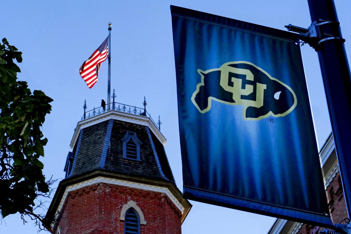 CU banner and American flag outside of Old Main