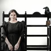 woman sitting on chair with raven
