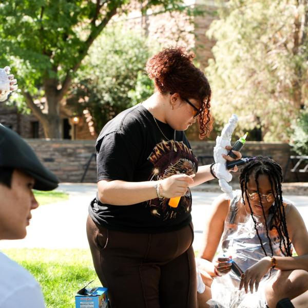 Connections student Isabella Herrera tie-dyes a shirt on the first day of the summer academy outside of Farrand hall.