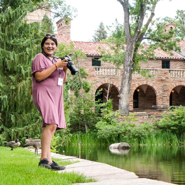 Connections student Estrella Hernandez takes photos at Varsity Lake on campus during a photography class.