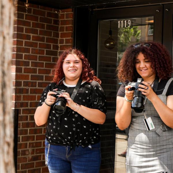 Connections participants, Isabella Herrera and Annika Garr, review their photos during a photography class.