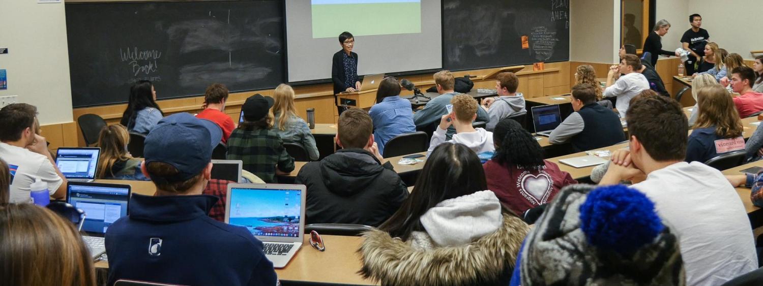 A faculty member lectures to a classroom full of undergraduate students
