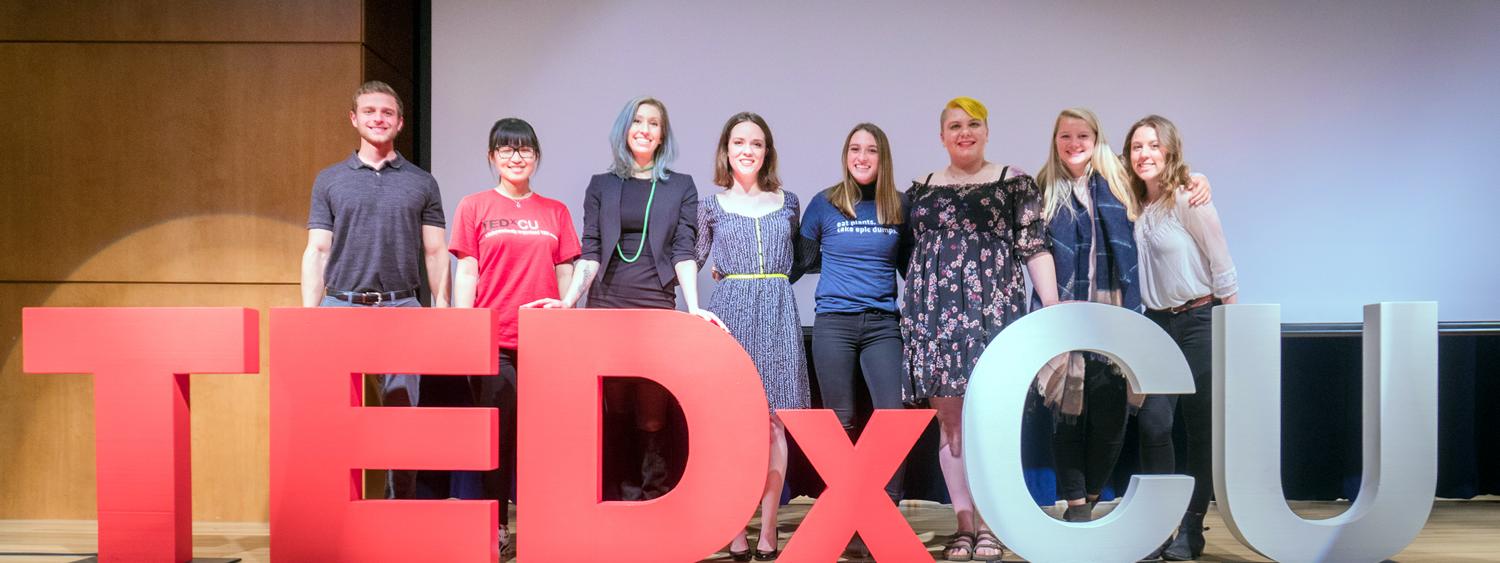Eight student TEDxCU presenters posing on stage.