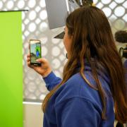 Two students test out a green screen and professional camera gear at J-Day.