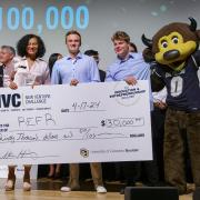 The Refr team poses with Chip, the Buffaloes mascot, and an oversize winning check on a stage.