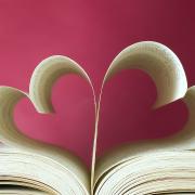 A book open to its center, with the pages curled up to look like hearts.