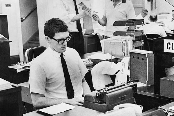 Students in the School of Journalism work on typewriters, pull feed from news wires, consult with faculty and develop photos in darkrooms, dates unknown. Source: University Libraries Rare and Distinctive Collections