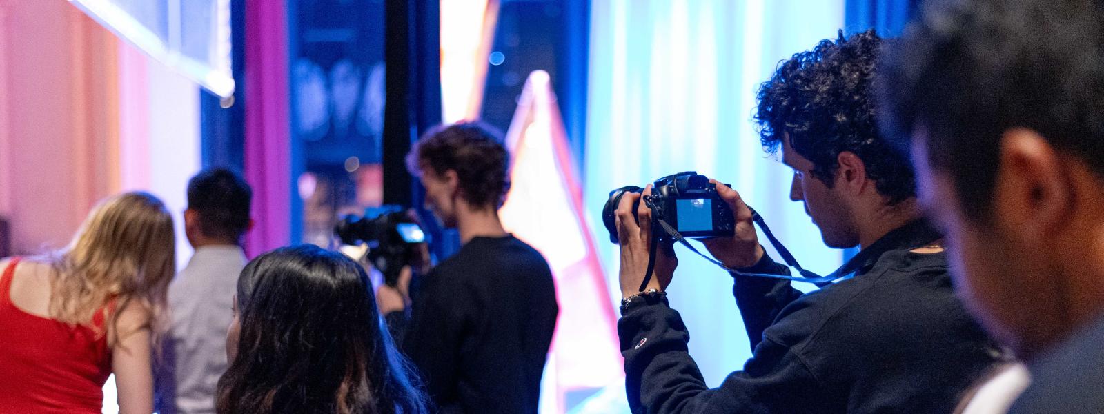 Student taking a photo backstage of TEDxCU
