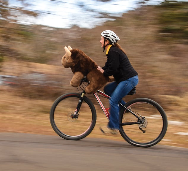 Woman and stuffed Buff ride a bike