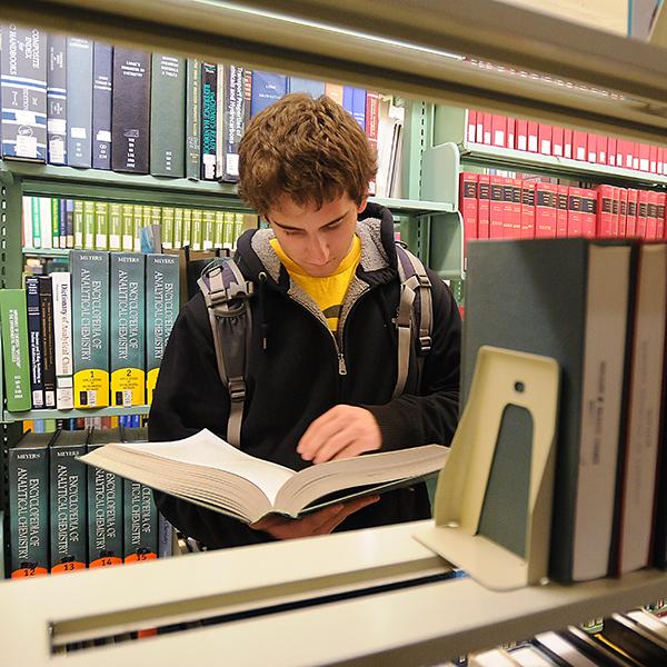 student reading a book in Norlin Library