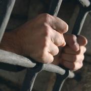 prisoner's hands on bars