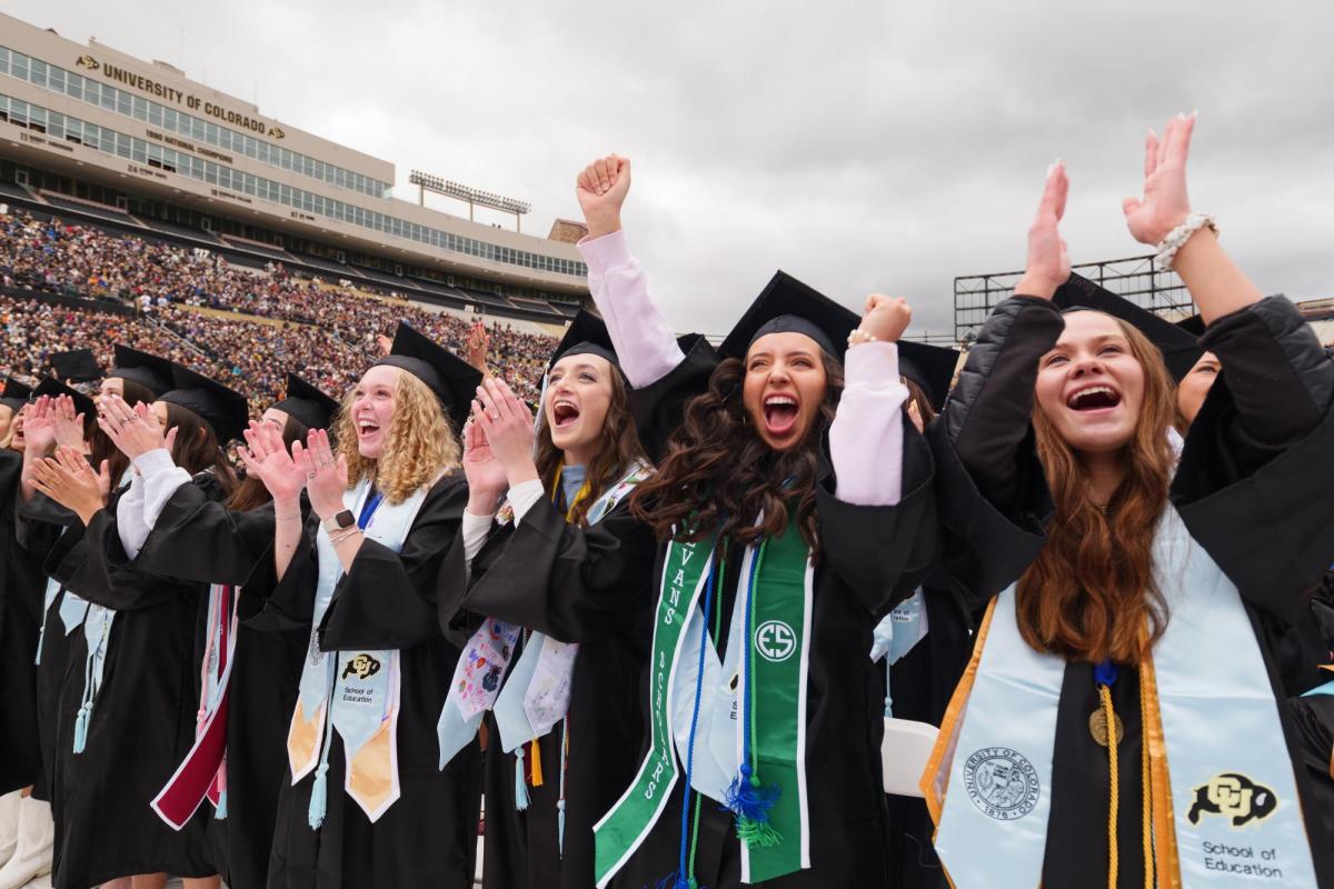 Students in Folsom Field celebrating their graduation