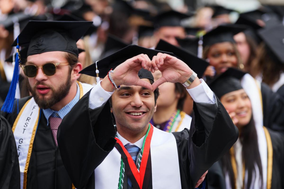 Recent graduate making heart symbol with their hands