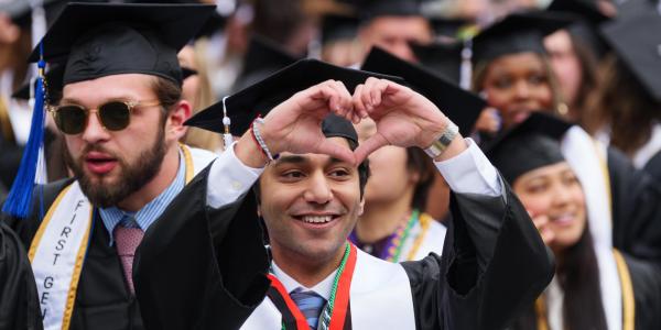 Recent graduate making heart symbol with their hands
